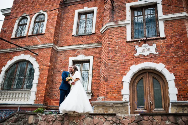 Весільна пара закохалася в фон старого цегляного будинку — стокове фото