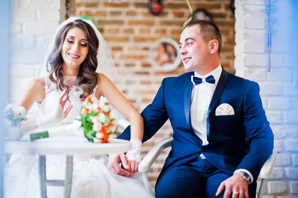 Casamento casal sentado a uma mesa em um café — Fotografia de Stock