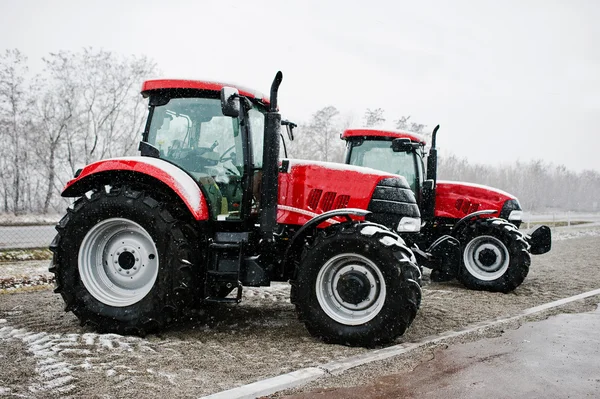 Twee nieuwe rode trekker verblijf in besneeuwde weer — Stockfoto