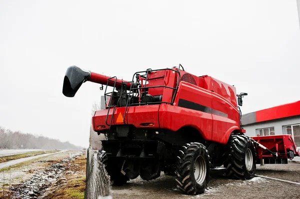 Achteraanzicht van de nieuwe rode combine harvester op besneeuwde weer — Stockfoto