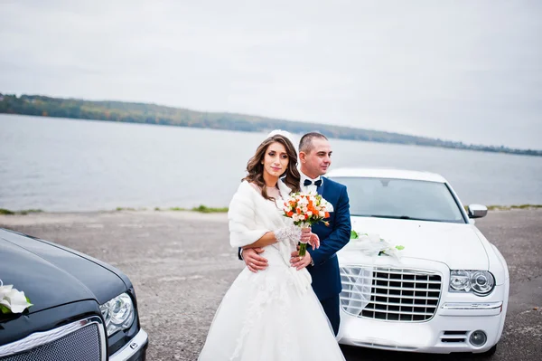 Esküvői pár háttérben két fekete-fehér esküvői autó — Stock Fotó