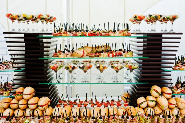 Mesa buffet de recepción con hamburguesas, snacks fríos, carne y sa —  Fotos de Stock