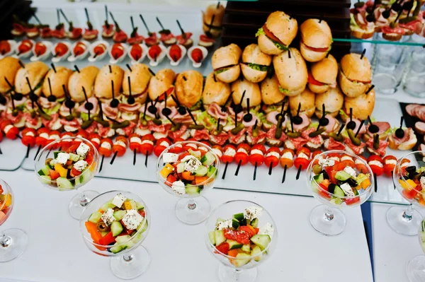 Buffet tavolo di ricevimento con hamburger, snack freddi, carne e sa — Foto Stock