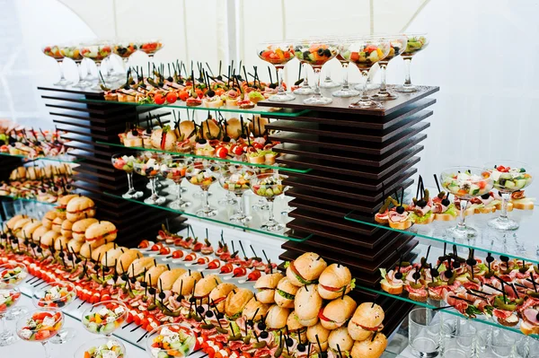 Buffet table of reception with burgers, cold snacks, meat and sa — Stock Photo, Image
