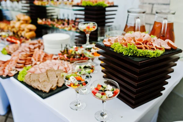 Mesa buffet de recepción con hamburguesas, snacks fríos, carne y sa —  Fotos de Stock