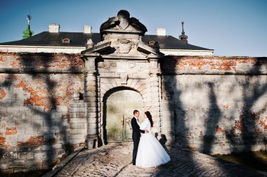 Güneşli havalarda arka plan duvar eski gölgeler ile çift düğün