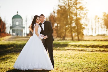 Şık Düğün çifti güneşli gün arka plan eski kilisede