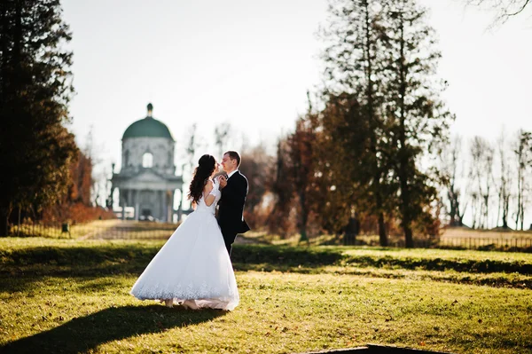 Modisches Hochzeitspaar am sonnigen Tag Hintergrund alte Kirche — Stockfoto