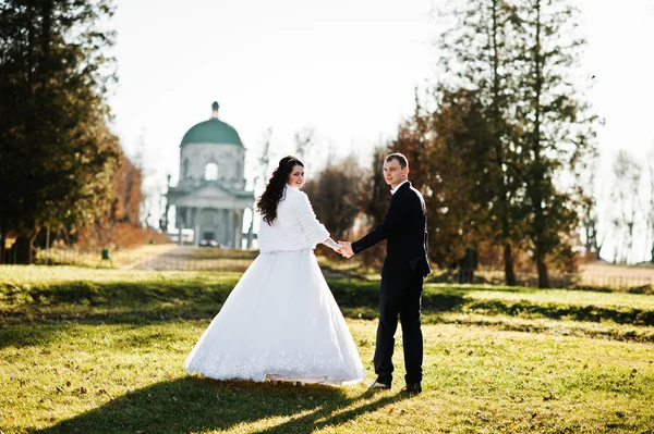 晴れた日の背景の古い教会でおしゃれな結婚式のカップル — ストック写真