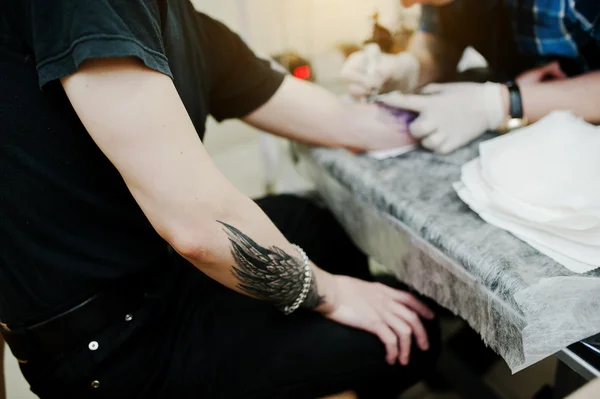 Tattoo master make tattoo for rocker man at tattoo salon — Stock Photo, Image