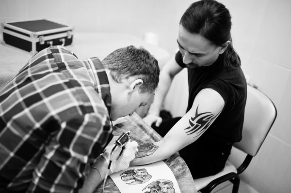 Tattoo master make tattoo for rocker man at tattoo salon — Stock Photo, Image