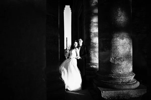 Impressionante casal de casamento colunas de fundo da antiga igreja do castelo — Fotografia de Stock