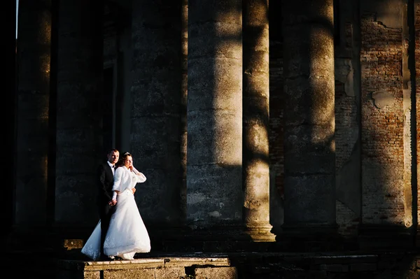 Impressionante matrimonio coppia sfondo colonne di vecchia chiesa del castello — Foto Stock