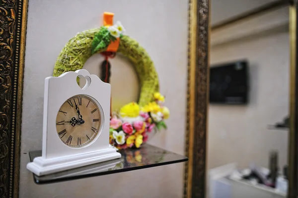 Reloj vintage antiguo decorado cerca de espejos en el salón de maquillaje — Foto de Stock