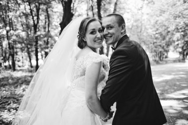 Geri gülümseyen çift arıyorum düğün moda. B&W fotoğraf