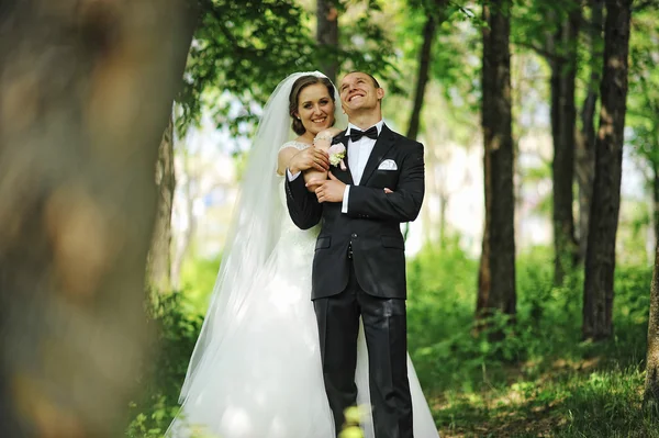 Stijlvolle geglimlacht jonggehuwden verblijf op park en knuffelen. — Stockfoto