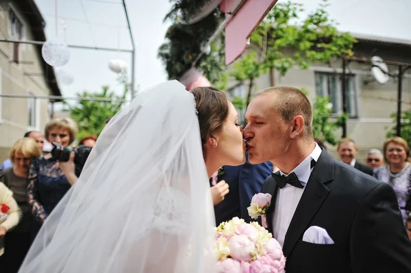 Beijar recém-casados na primeira reunião na cerimônia de casamento — Fotografia de Stock