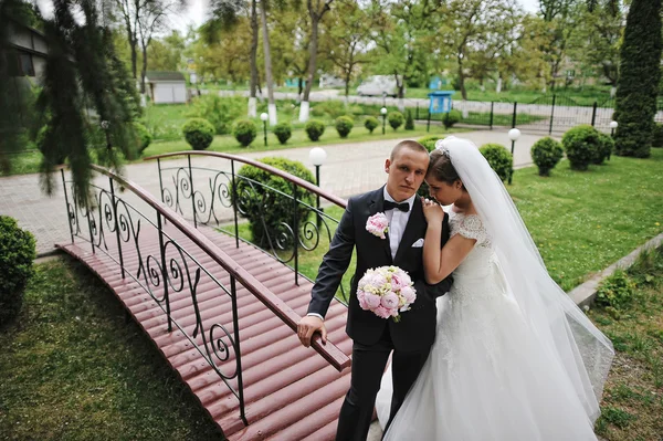 Casal de moda jovem ficar perto de pequena ponte — Fotografia de Stock