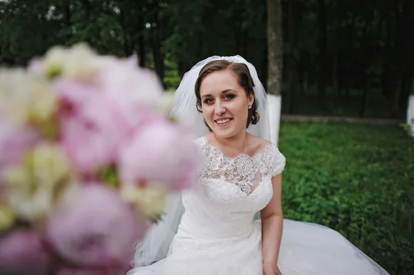 Linda noiva mostrando peônias buquê de casamento na mão — Fotografia de Stock