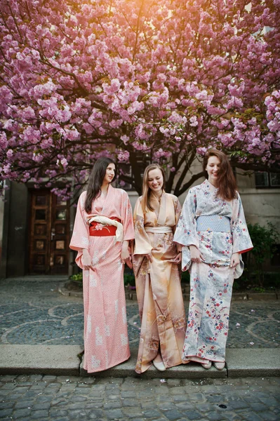 Három európai lány visel hagyományos japán kimonó backgro — Stock Fotó