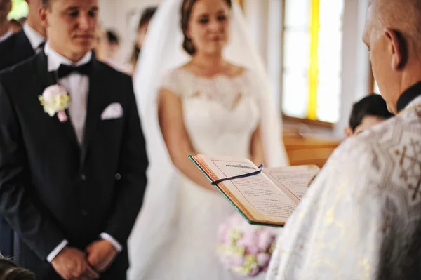 Prêtre lu une sainte Bible fond du livre jeunes mariés — Photo