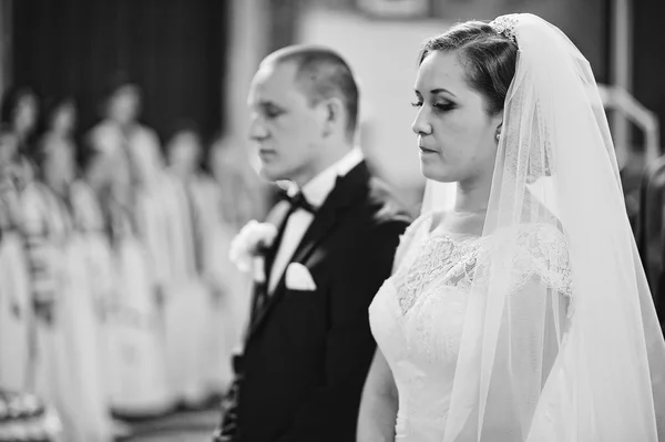 Close-up van portret van ernstige bruidspaar bij kerkelijke achtergrond — Stockfoto