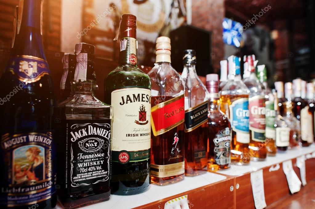 KYIV, UKRAINE - MARCH 25, 2016: Various alcoholic beverages bottles in the bar. Jack Daniels, Jameson and Red Label at center