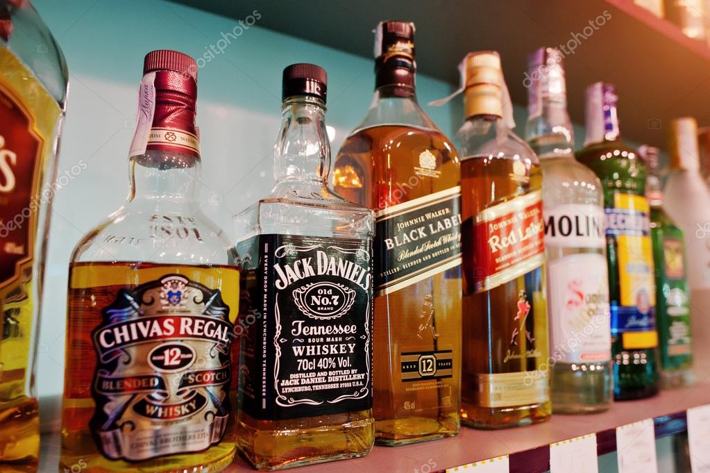 KYIV, UKRAINE - MARCH 25, 2016: Various alcoholic beverages bottles in the bar. Chivas Regal, Jack Daniel's and Black Label at center