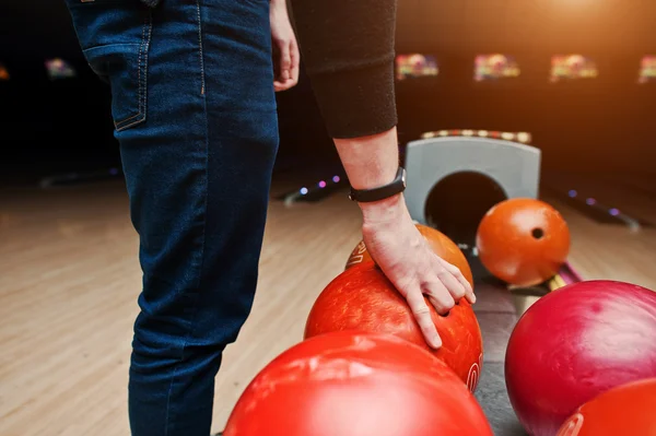 Nahaufnahme der Hand eines Bowlingspielers, der einen roten Ball aus dem Bowlinglift nimmt — Stockfoto