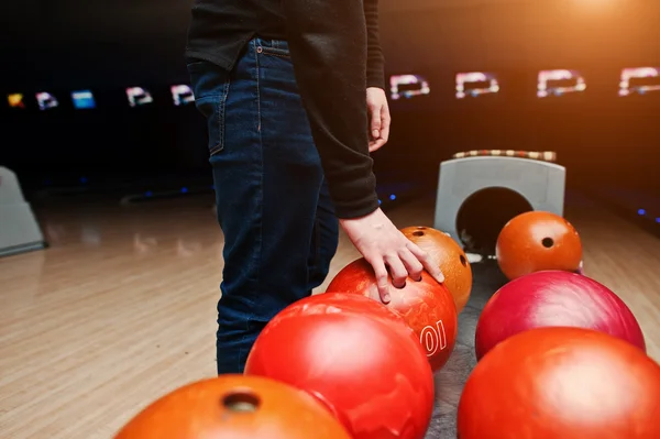 Nahaufnahme der Hand eines Bowlingspielers, der einen roten Ball aus dem Bowlinglift nimmt — Stockfoto