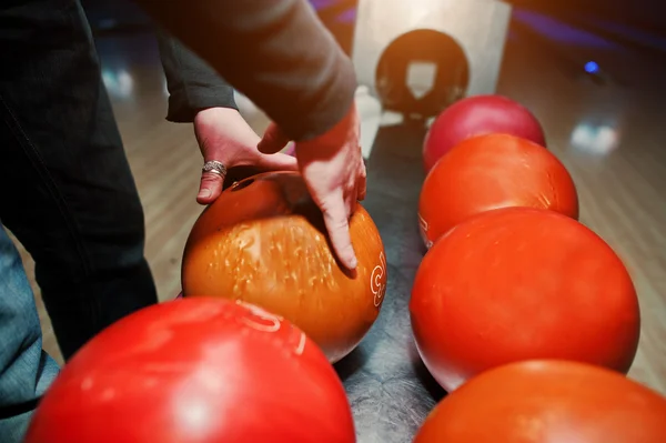 Detailní záběr bowlingové hráče rukou s oranžová koule z mísy lif — Stock fotografie