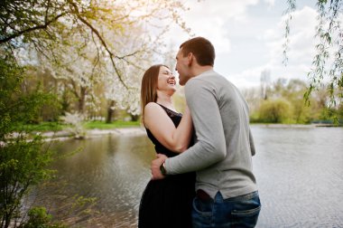 Genç çift aşık açık. Gülmek ve huggs arka plan Gölü