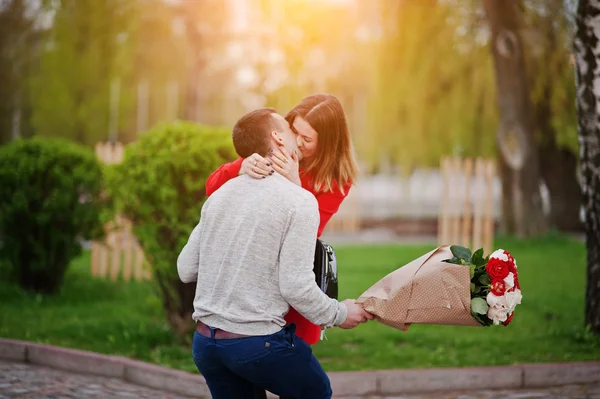 Предложение о браке. Поцелуй девушки и парня с букетом гриппа — стоковое фото