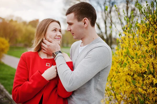 Liebespaar umarmt sich an einem Strauch mit gelber Blume — Stockfoto