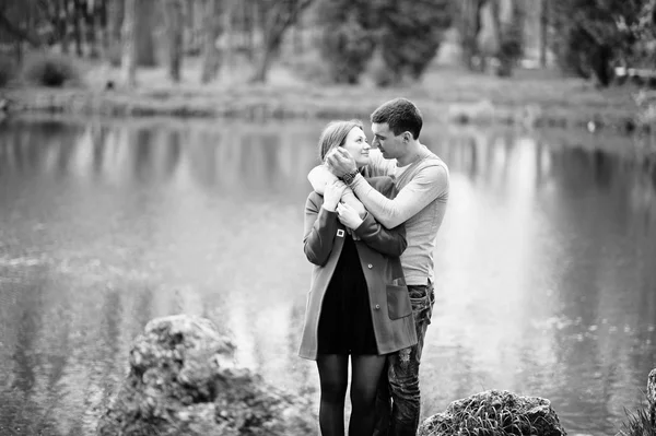 Feliz casal amoroso ficar e abraçar no lago fundo do parque. B — Fotografia de Stock