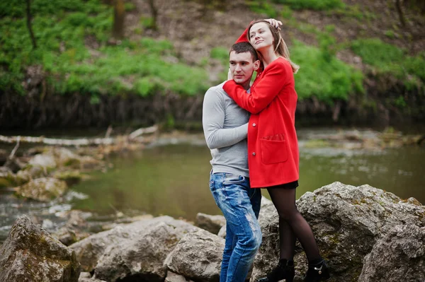Cuddling pareja permanecer en piedras en el río. Pareja enamorada. Amor co — Foto de Stock