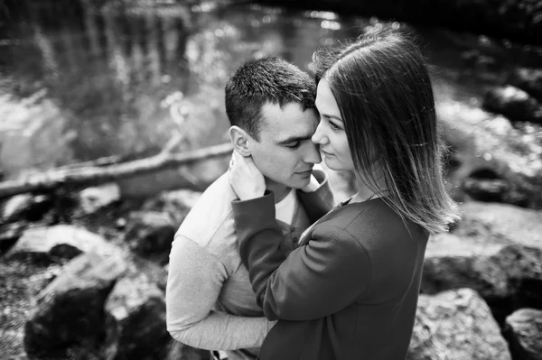 Cuddling couple stay at stones in river. Couple in love. Love co — Stock Photo, Image