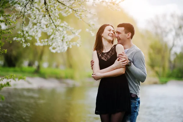 Casal jovem no amor ao ar livre. Rir e abraços fundo lago — Fotografia de Stock