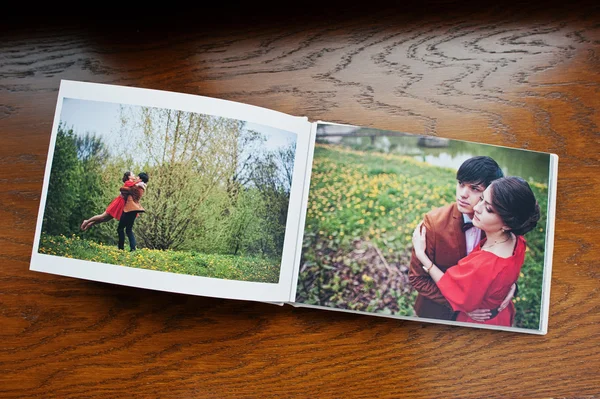 Abrir páginas de álbum de fotolibro pareja enamorada sobre fondo de madera — Foto de Stock