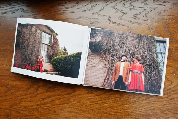Open pages of album photobook couple in love on wooden backgroun — Stock Photo, Image