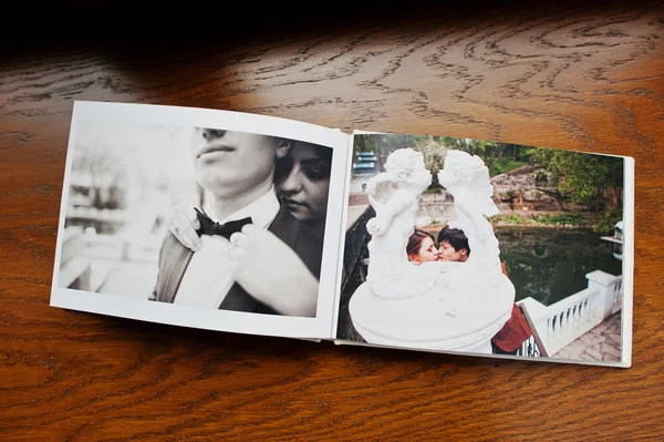 Open pages of album photobook couple in love on wooden backgroun — Stock Photo, Image