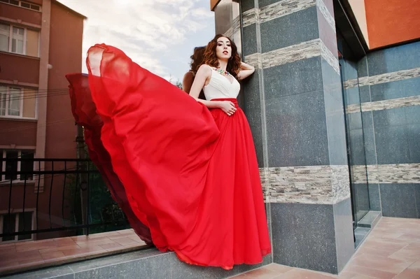 Portrait of fashionable girl at red evening dress posed backgrou — Stock Photo, Image