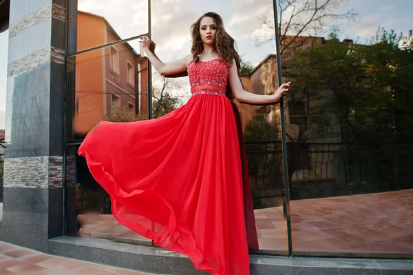 Портрет модной девушки в красном вечернем платье позировал backgrou — стоковое фото