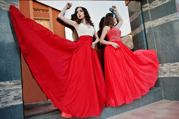 Deux filles à la mode à robe de soufflage de soirée rouge dans l'air po — Photo