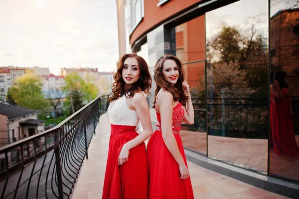 Portret dwóch modnych dziewcząt w czerwony strój wieczorowy stwarzane bac — Zdjęcie stockowe