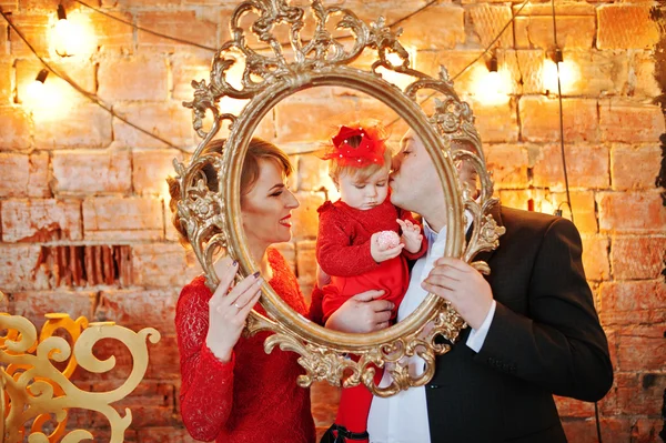 Glückliche Familie mit Tochter schaut durch einen goldenen Vintage-Rahmen — Stockfoto