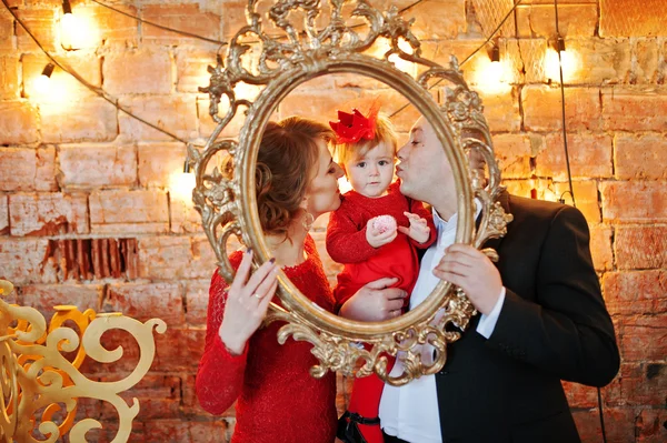 Glückliche Familie mit Tochter schaut durch einen goldenen Vintage-Rahmen — Stockfoto