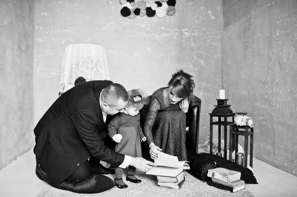 Família feliz com a filha ler o livro velho sobre tapetes de fundo — Fotografia de Stock