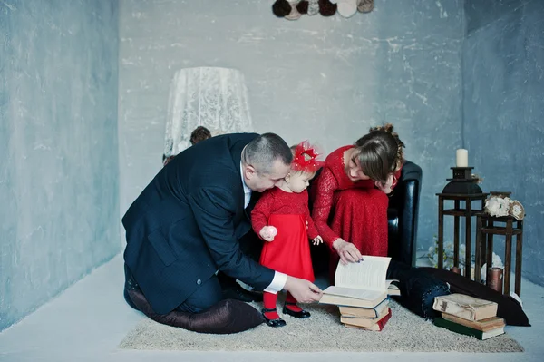 Glückliche Familie mit Tochter las das alte Buch auf Teppichen Hintergrund — Stockfoto