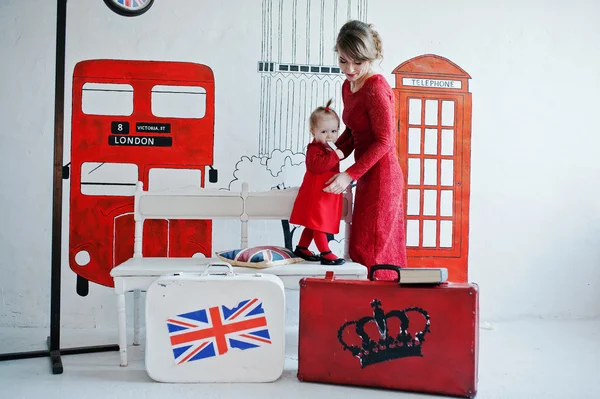 Encantador bebé y su madre en vestido rojo, fondo tema de Inglaterra — Foto de Stock